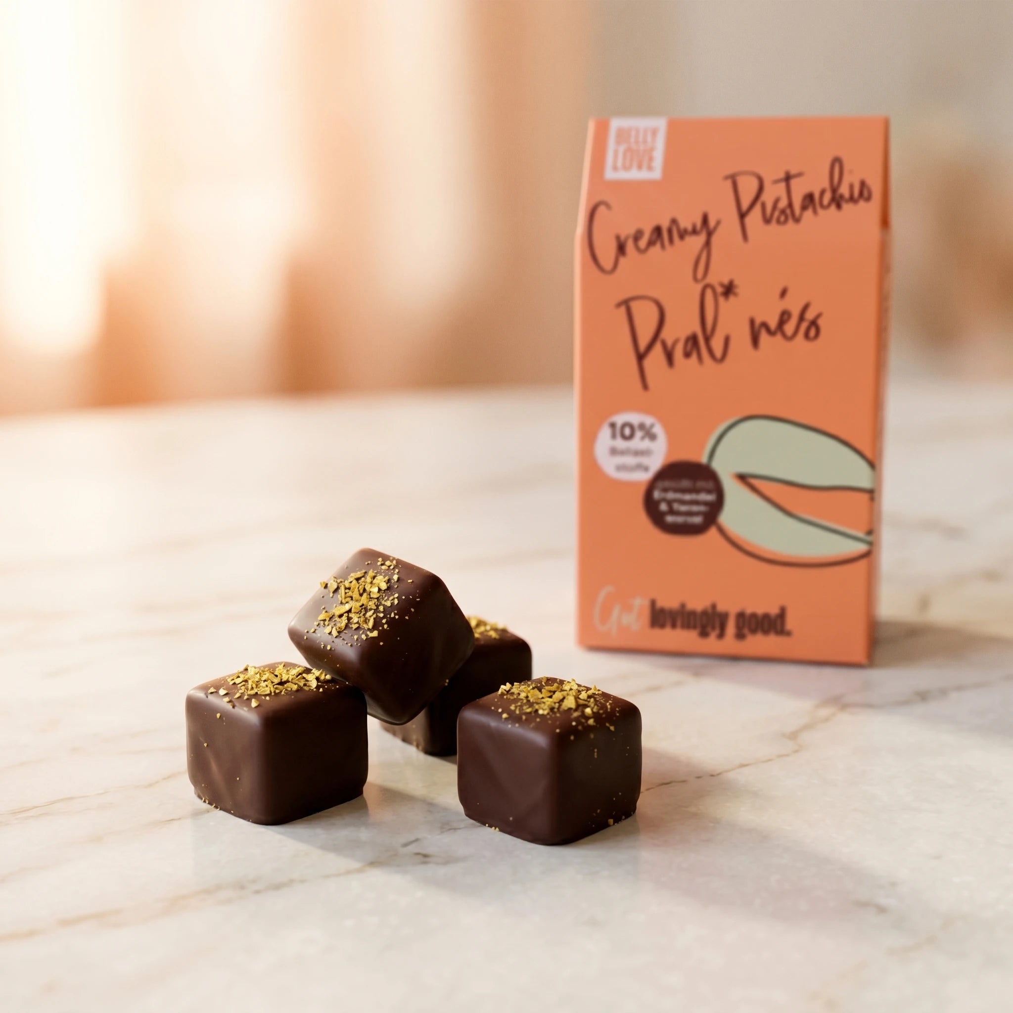 Belly Love Pistachio Pralinés auf Marmor, Verpackung bokeh – industriezuckerfrei