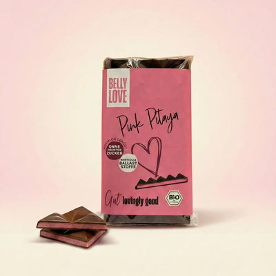 Tafel (verpackt und angeschnitten) Pink Pitaya mit dunkler Alternative zu Schokolade und gefriergetrockneter Himbeere und Drachenfrucht. Ohne Industriezucker, natürlich gesüßt, ballaststoffreich, vegan, bio.